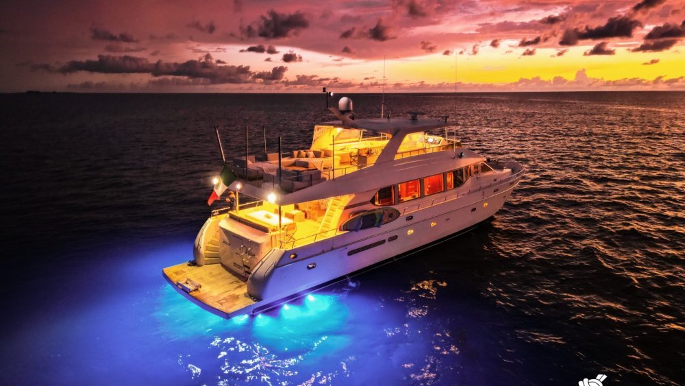 Montefino 84 luxury yacht lit up at sunset on Banderas Bay, aerial photograph of a Puerto Vallarta yacht charter